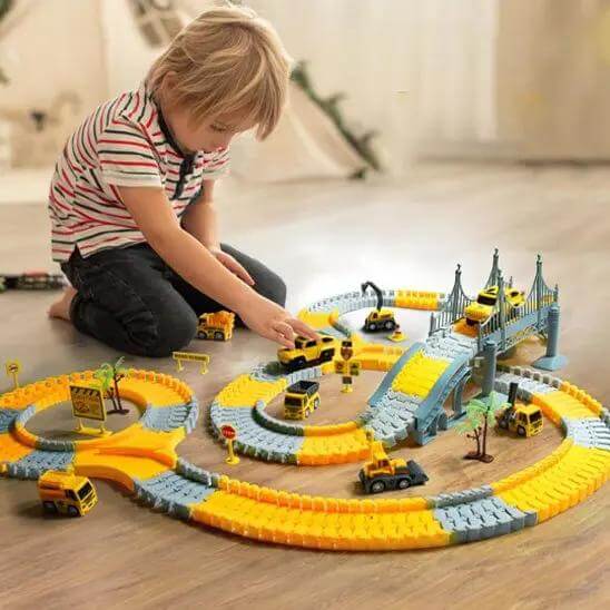 un garçon qui joue avec  son circuit voiture - Monde à maman