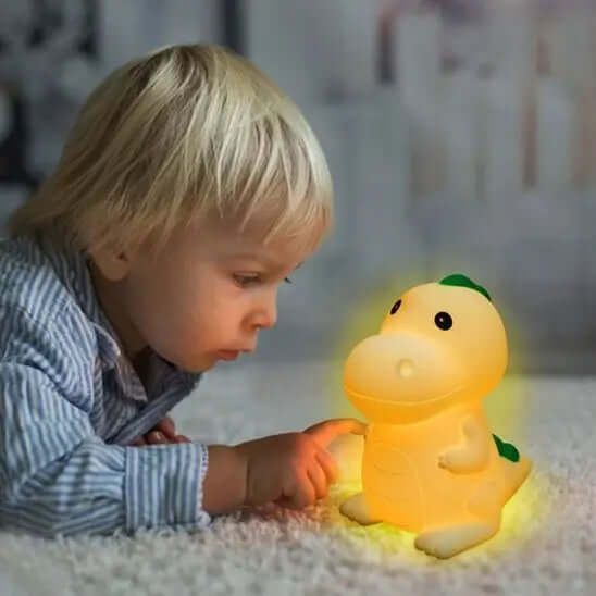 Veilleuse dinosaure et un garcon qui le touche - Monde à maman