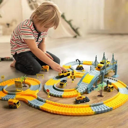 un garçon qui joue avec  son circuit voiture - Monde à maman